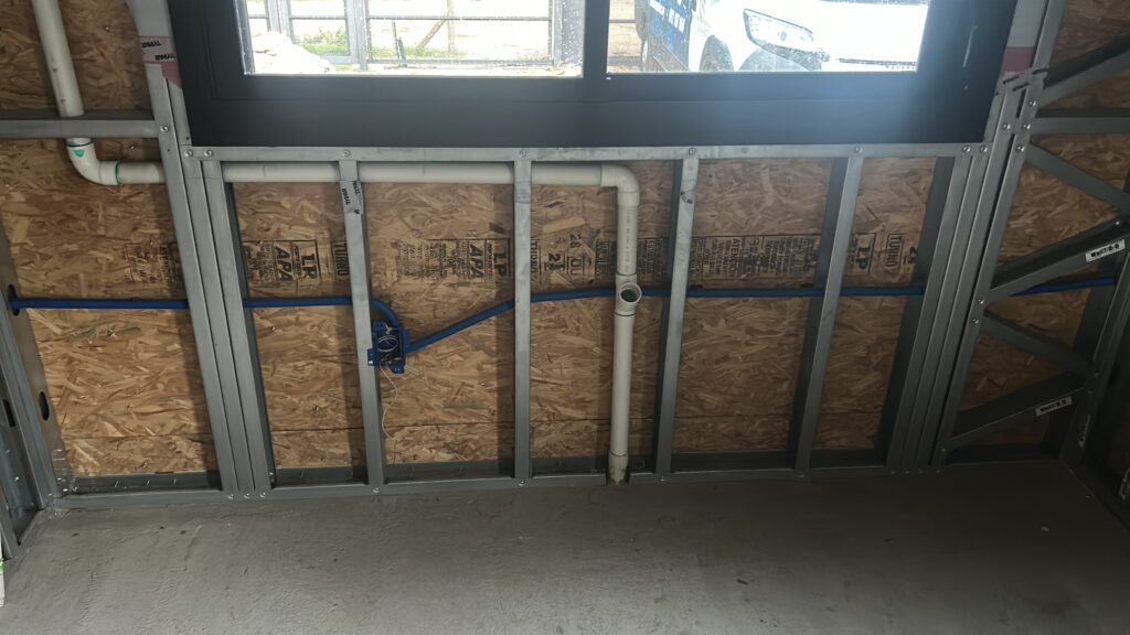 Cañerías eléctricas y sanitarias embutidas en estructura de steel framing antes del cierre de muros